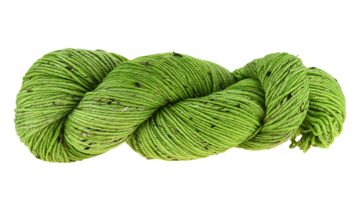 A twisted skein of Barn Yarn hand-dyed tweed DK weight yarn in colorway Envy - a vibrant avocado green shade, perfect for bold knitting and crochet projects.