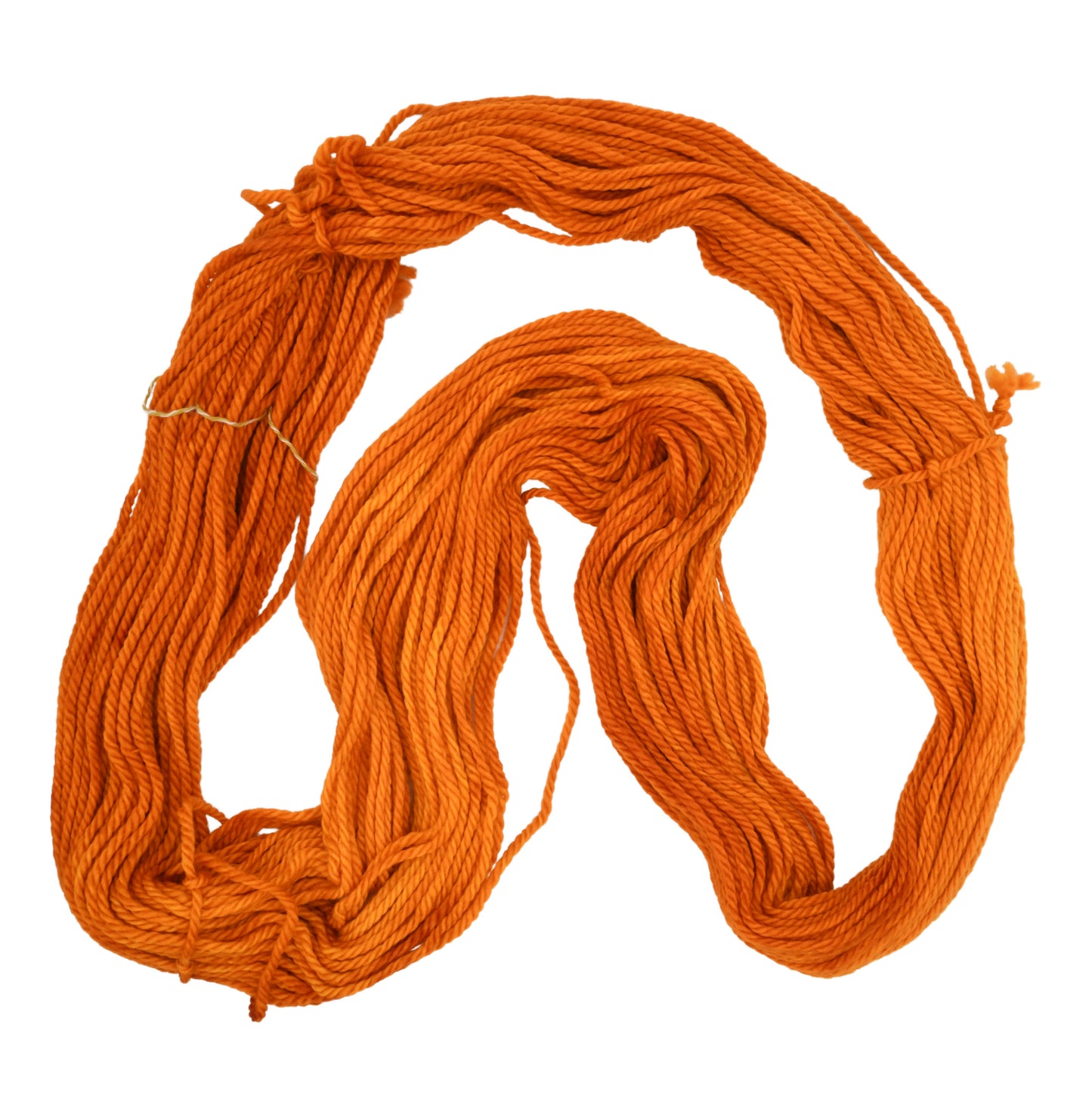 An unfolded skein of Barn Yarn bulky weight hand-dyed yarn in colorway Pumpkin Orange in a bold, glowing orange shade, perfect for knitting and crochet projects with autumn warmth.