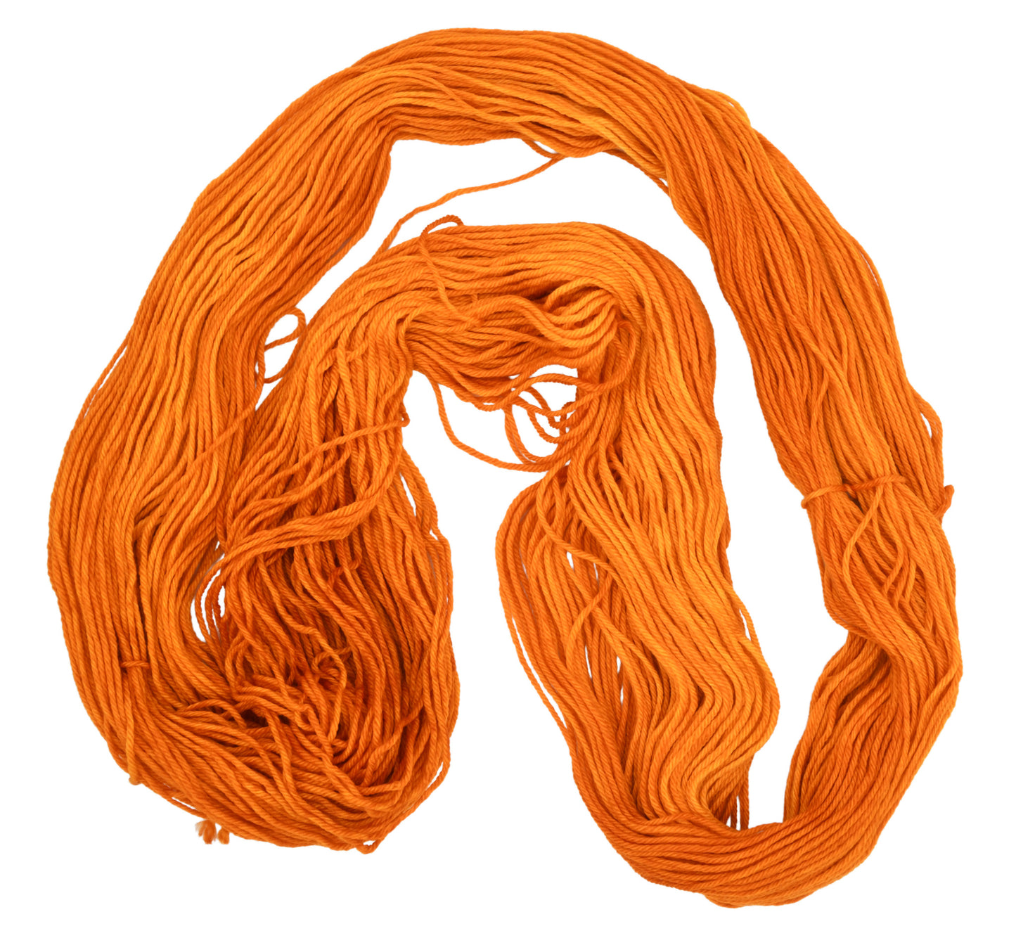 An unfolded skein of Barn Yarn merino/cashmere/nylon fingering weight hand-dyed yarn in colorway Pumpkin Orange in a bold, glowing orange shade, perfect for knitting and crochet projects with autumn warmth.