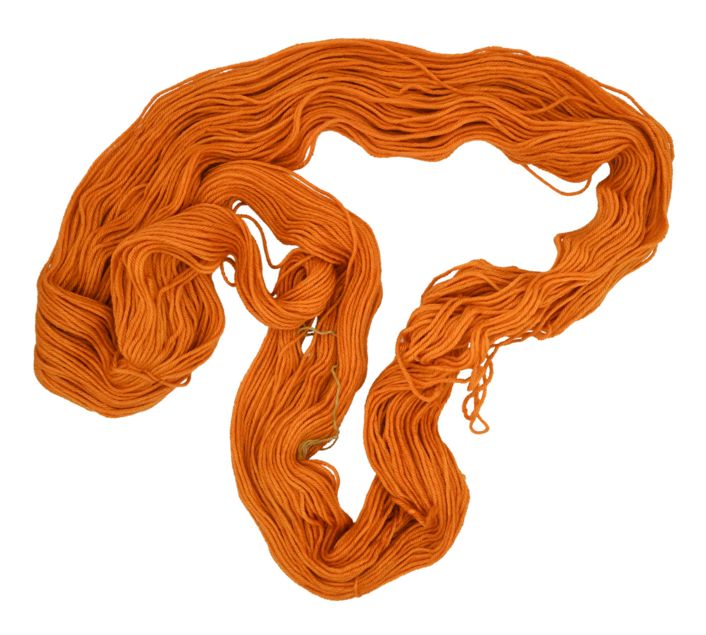 An unfolded skein of Barn Yarn worsted hand-dyed yarn in colorway Pumpkin Orange in a bold, glowing orange shade, perfect for knitting and crochet projects with autumn warmth.