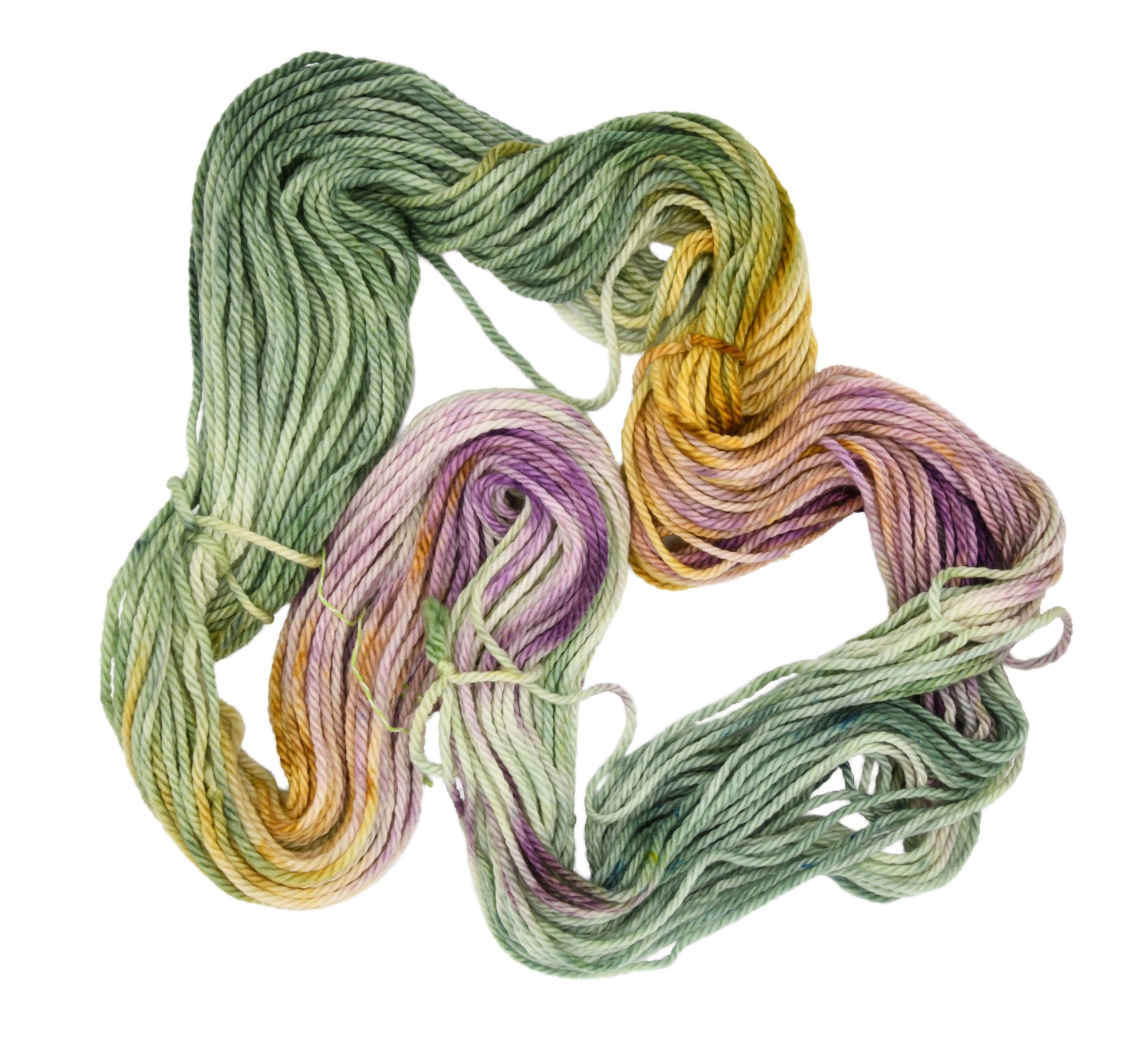 An unfolded skein of Barn Yarn hand-dyed bulky weight yarn in colorway Pistachio, soft green shades with creamy toffee and purple undertones, perfect for fresh and playful knitting and crochet projects.