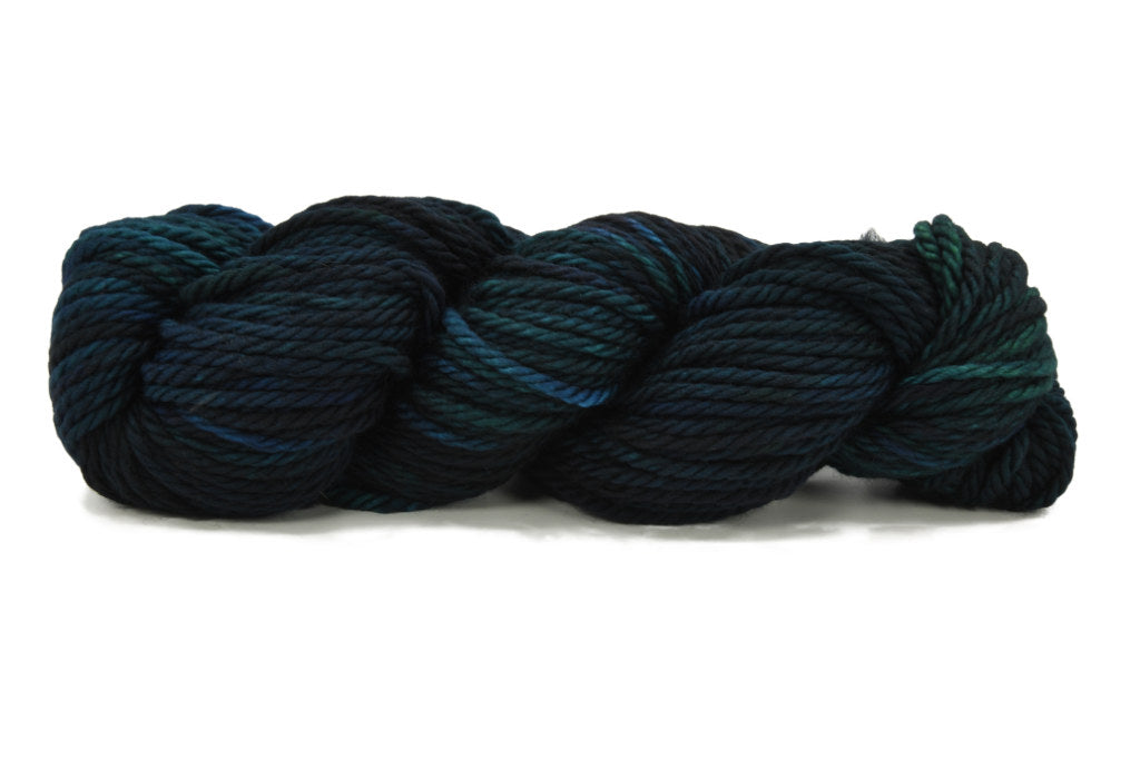 A twisted skein of Barn Yarn hand-dyed bulky weight yarn in colorway Raven -deep blue and black, perfect for bold, moody knitting and crochet projects.
