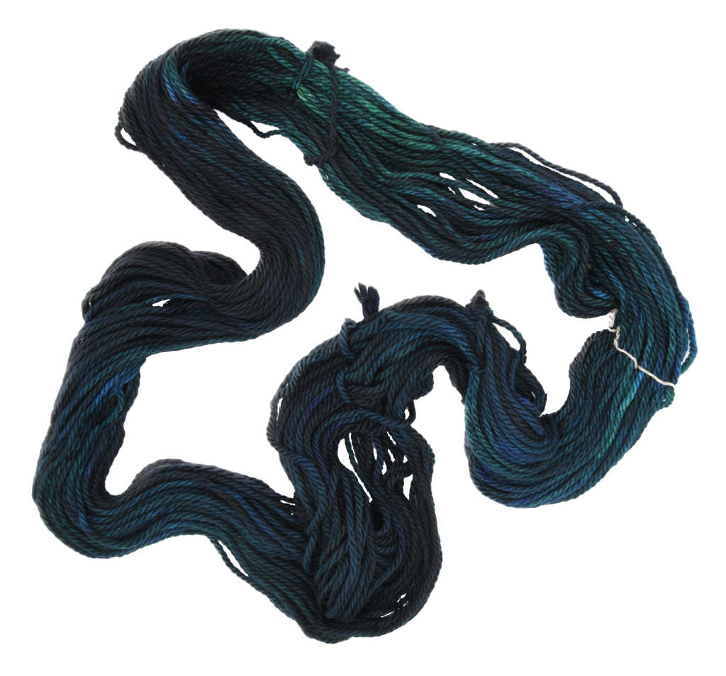 An unfolded skein of Barn Yarn hand-dyed bulky weight yarn in colorway Raven -deep blue and black, perfect for bold, moody knitting and crochet projects.