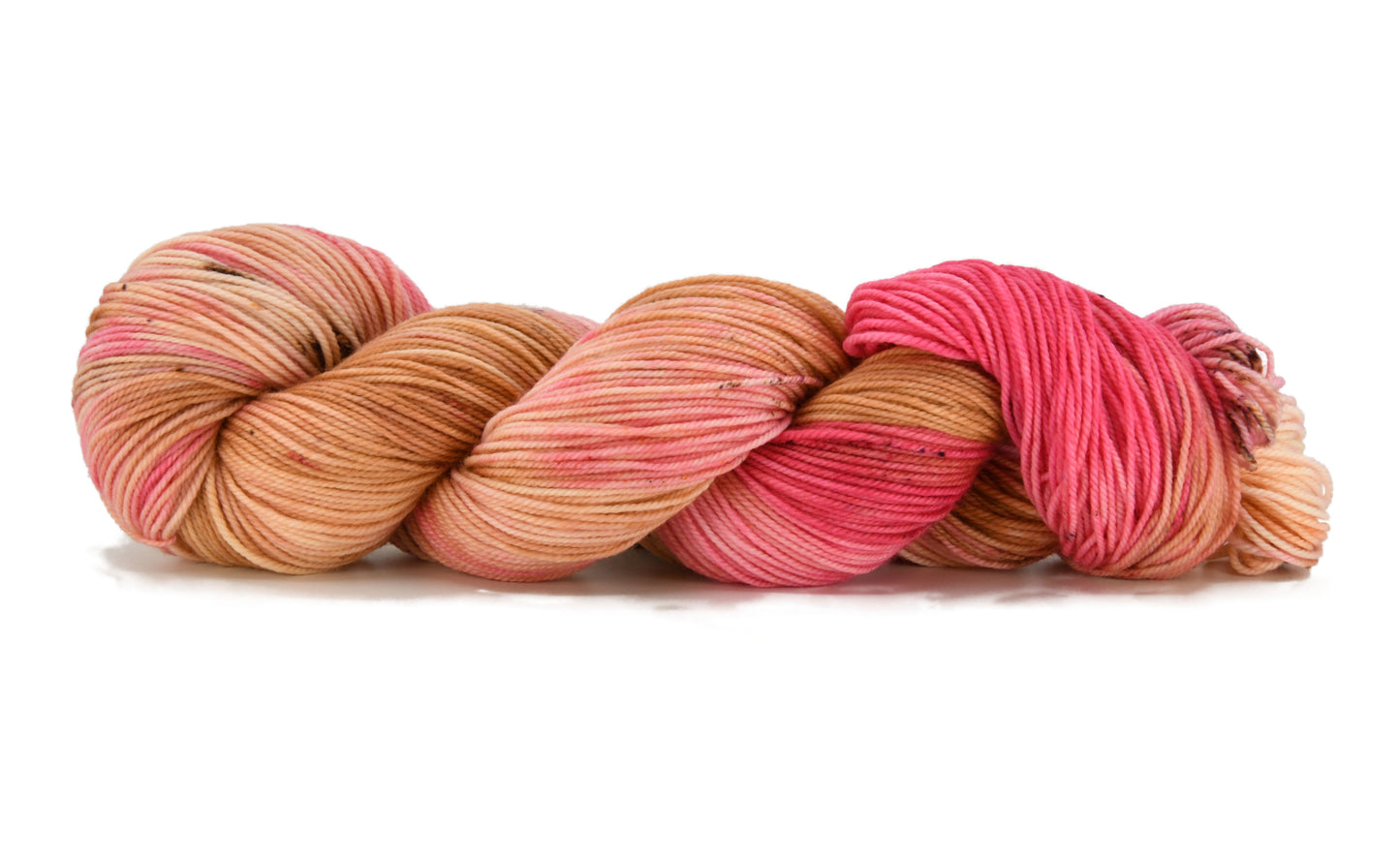 A twisted skein of Barn Yarn hand-dyed sport weight yarn in colorway Poolside Popsicle featuring bright strawberry pink, vanilla and chocolate sprinkles, perfect for knitting and crochet projects.