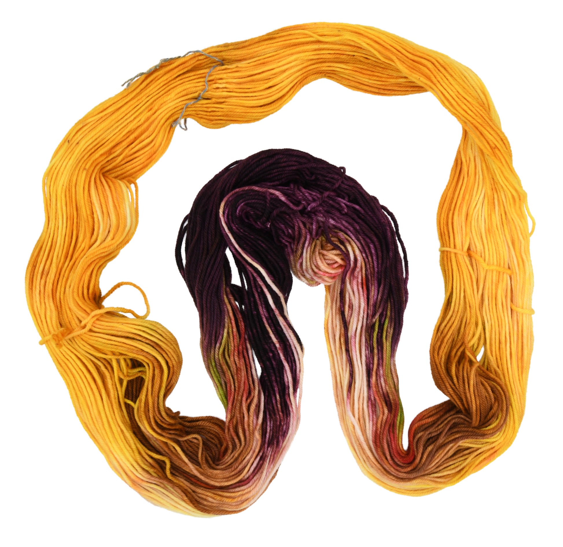 An unfolded skein of Barn Yarn hand-dyed DK weight yarn in colorway Fallen Leaves featuring warm autumn tones of brown, gold, red, and green, perfect for cozy knitting and crochet projects.