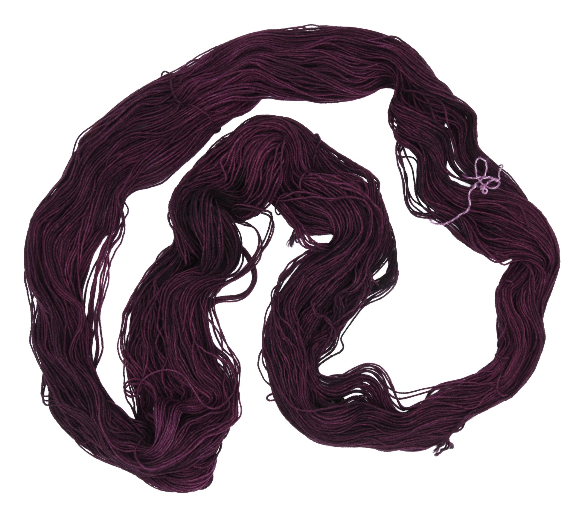 An unfolded skein of Barn Yarn hand-dyed fingering weight yarn in colorway Plum; a rich, deep purple shade, perfect for sophisticated knitting and crochet projects.