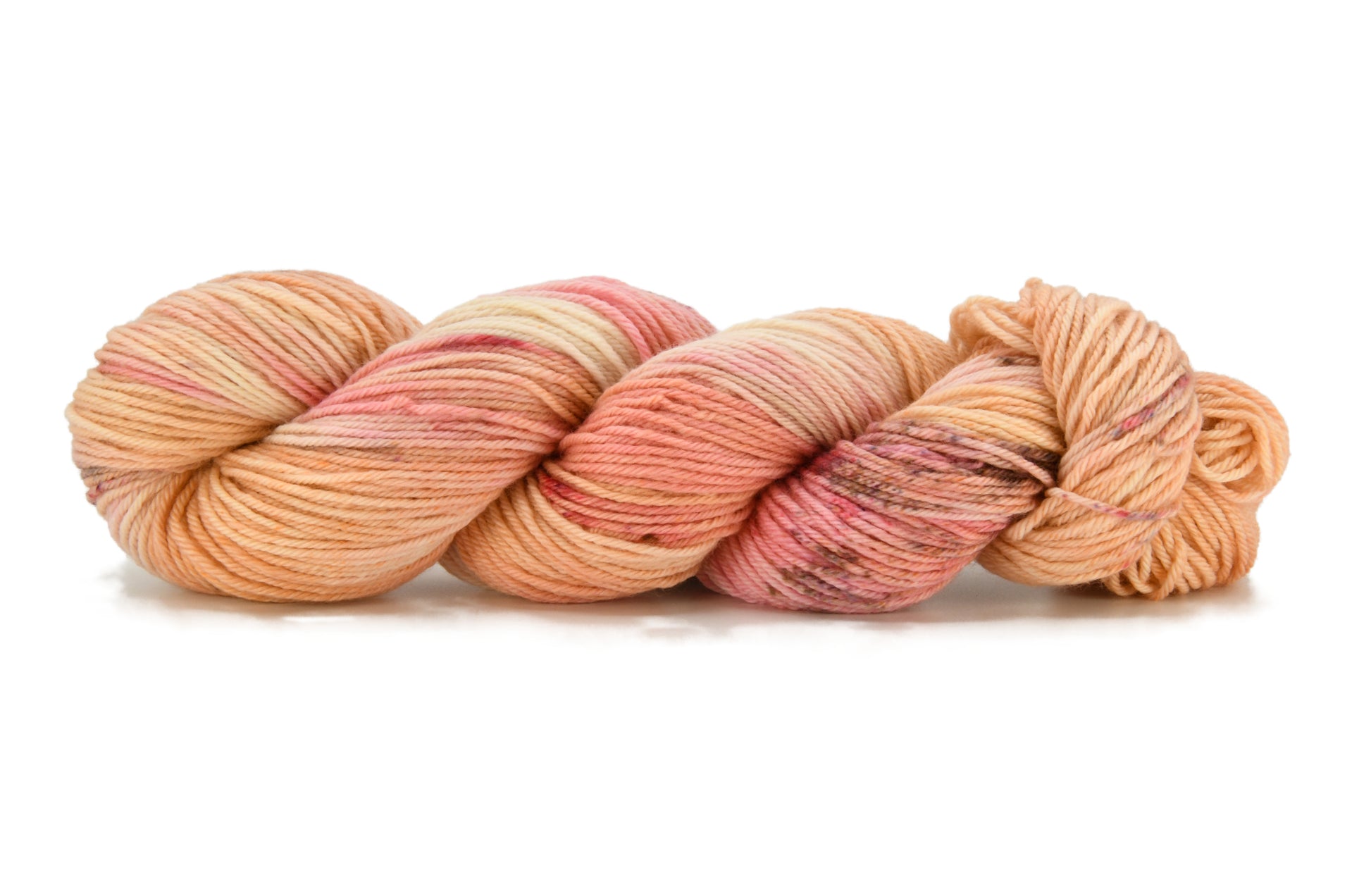 A twisted skein of Barn Yarn hand-dyed worsted weight yarn in colorway Poolside Popsicle featuring bright strawberry pink, vanilla and chocolate sprinkles, perfect for  knitting and crochet projects.