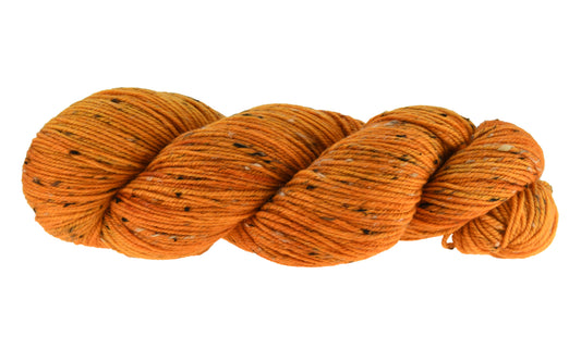 A twisted skein of Barn Yarn Tweed DK hand-dyed yarn in colorway Pumpkin Orange in a bold, glowing orange shade, perfect for knitting and crochet projects with autumn warmth.
