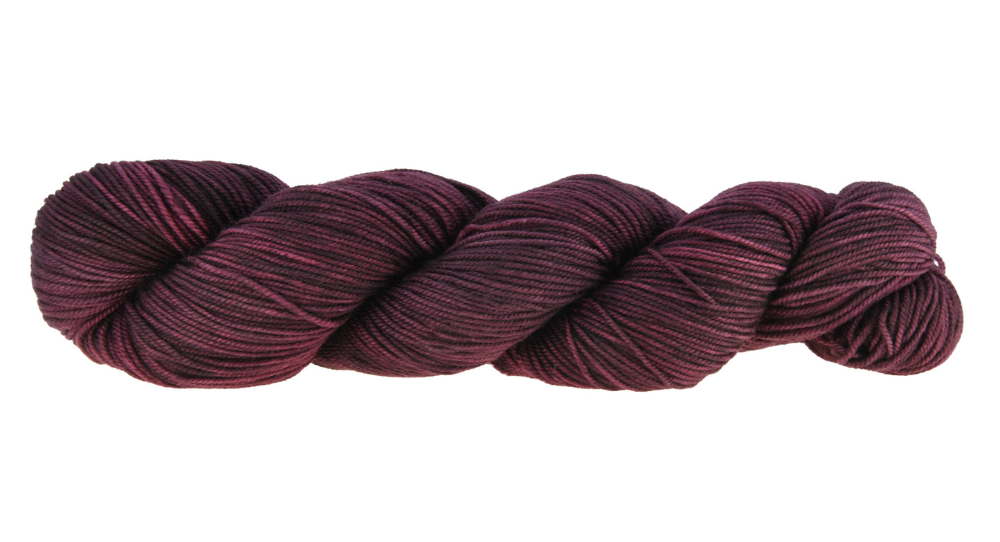 A twisted skein of Barn Yarn hand-dyed sport weight yarn in colorway Plum; a rich, deep purple shade, perfect for sophisticated knitting and crochet projects.
