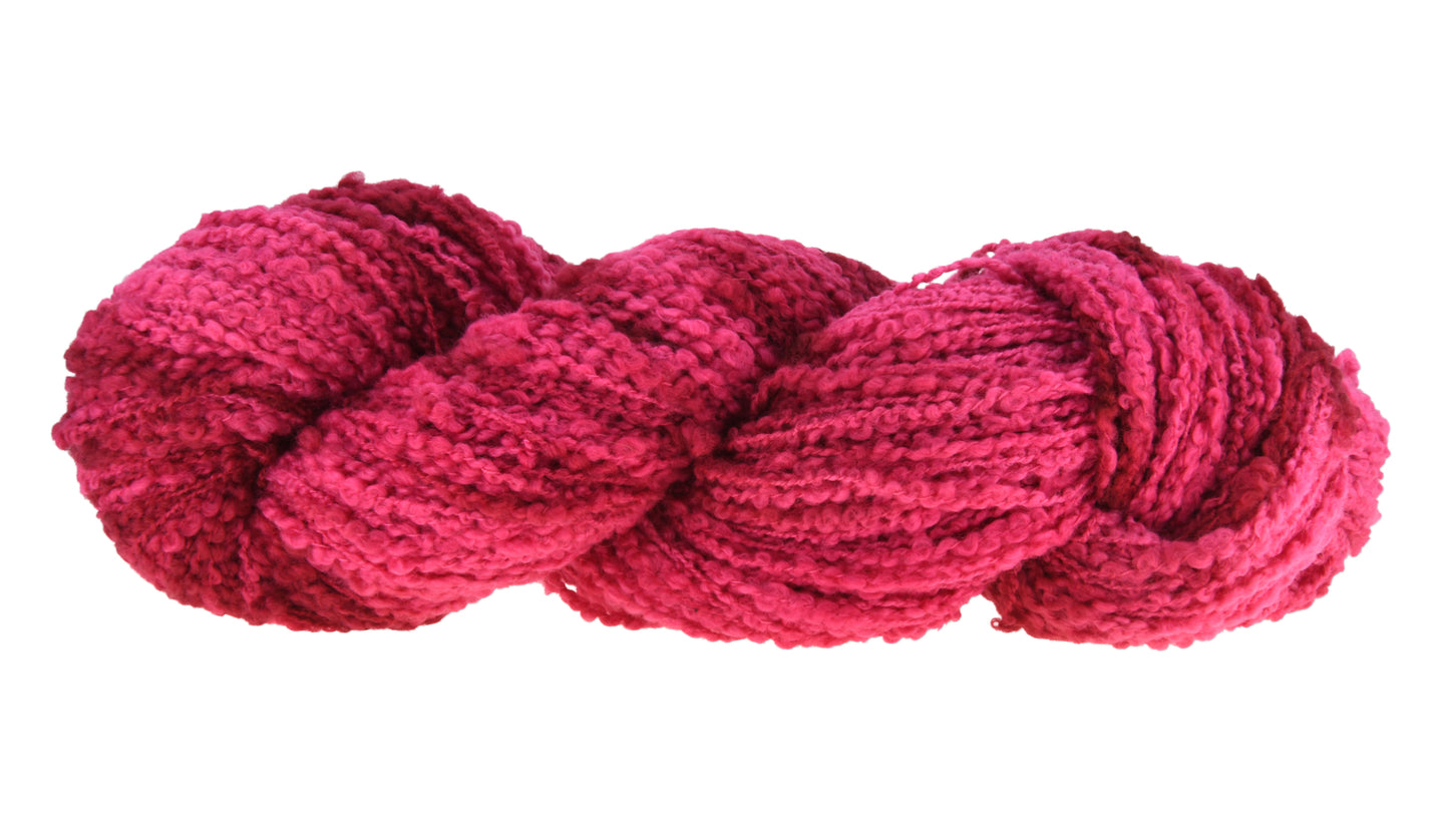A twisted hank of Boucle DK weight hand-dyed yarn in colorway Pomegranate featuring layered bright and dark saturated pink tones, ideal for vibrant handmade creations.