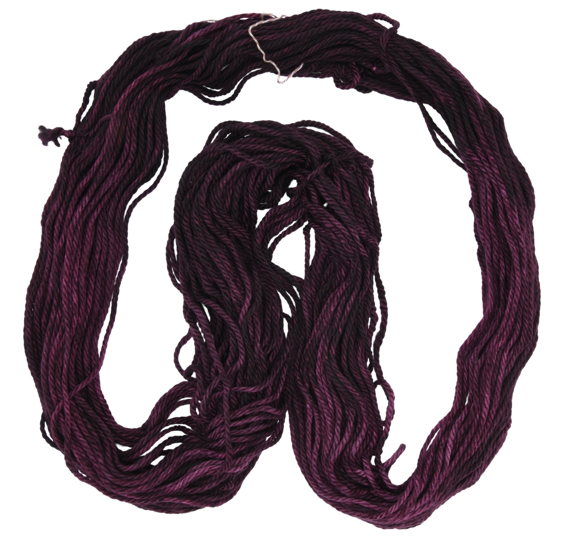 An unfolded skein of Barn Yarn hand-dyed bulky weight yarn in colorway Plum; a rich, deep purple shade, perfect for sophisticated knitting and crochet projects.