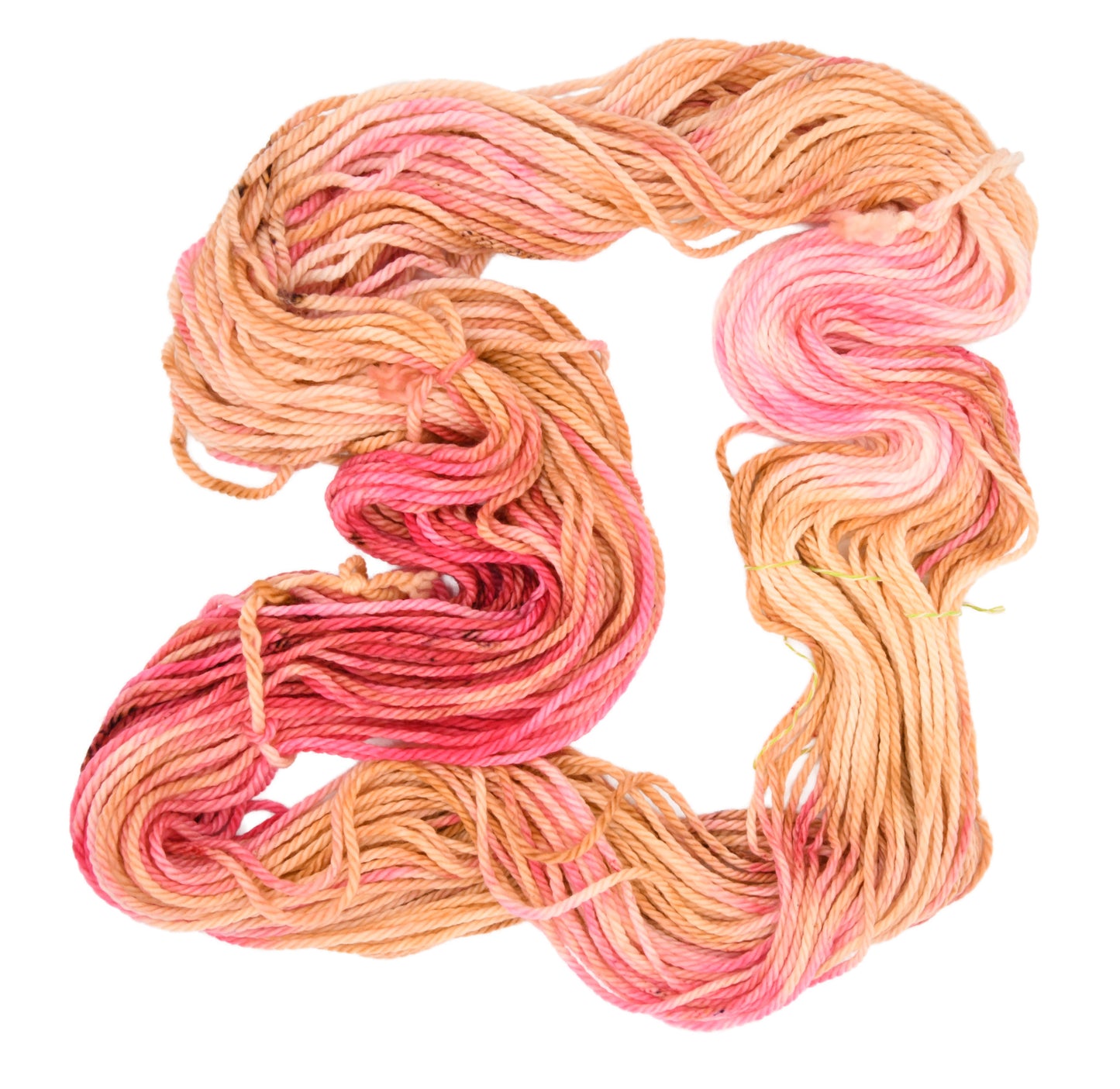 An unfolded skein of Barn Yarn hand-dyed bulky weight yarn in colorway Poolside Popsicle featuring bright strawberry pink, vanilla and chocolate sprinkles, perfect for  knitting and crochet projects.