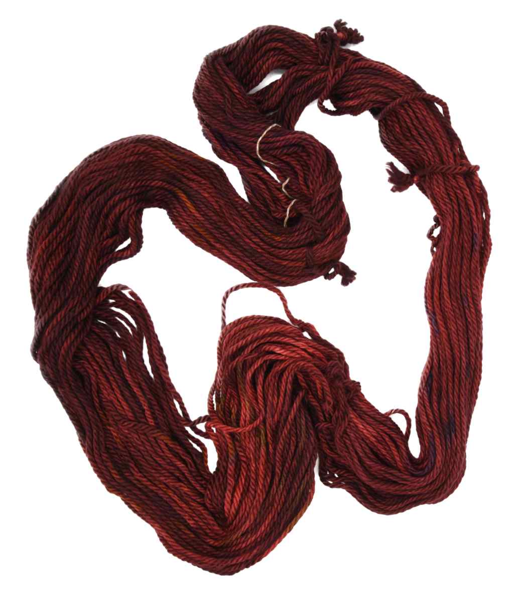 An unfolded skein of Barn Yarn hand-dyed bulky weight yarn in Cinnabar - deep red with earthy undertones, perfect for bold and cozy knitting and crochet projects.