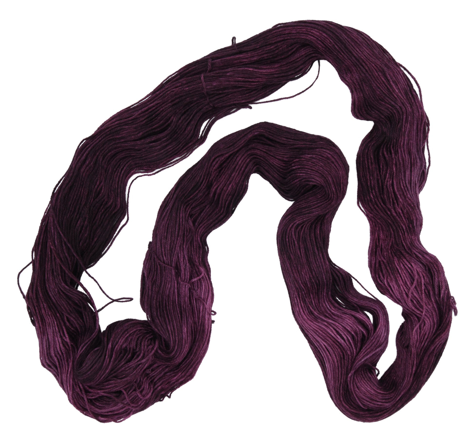 An unfolded skein of Barn Yarn hand-dyed merino-cashmere-nyon blend yarn in colorway Plum; a rich, deep purple shade, perfect for sophisticated knitting and crochet projects.