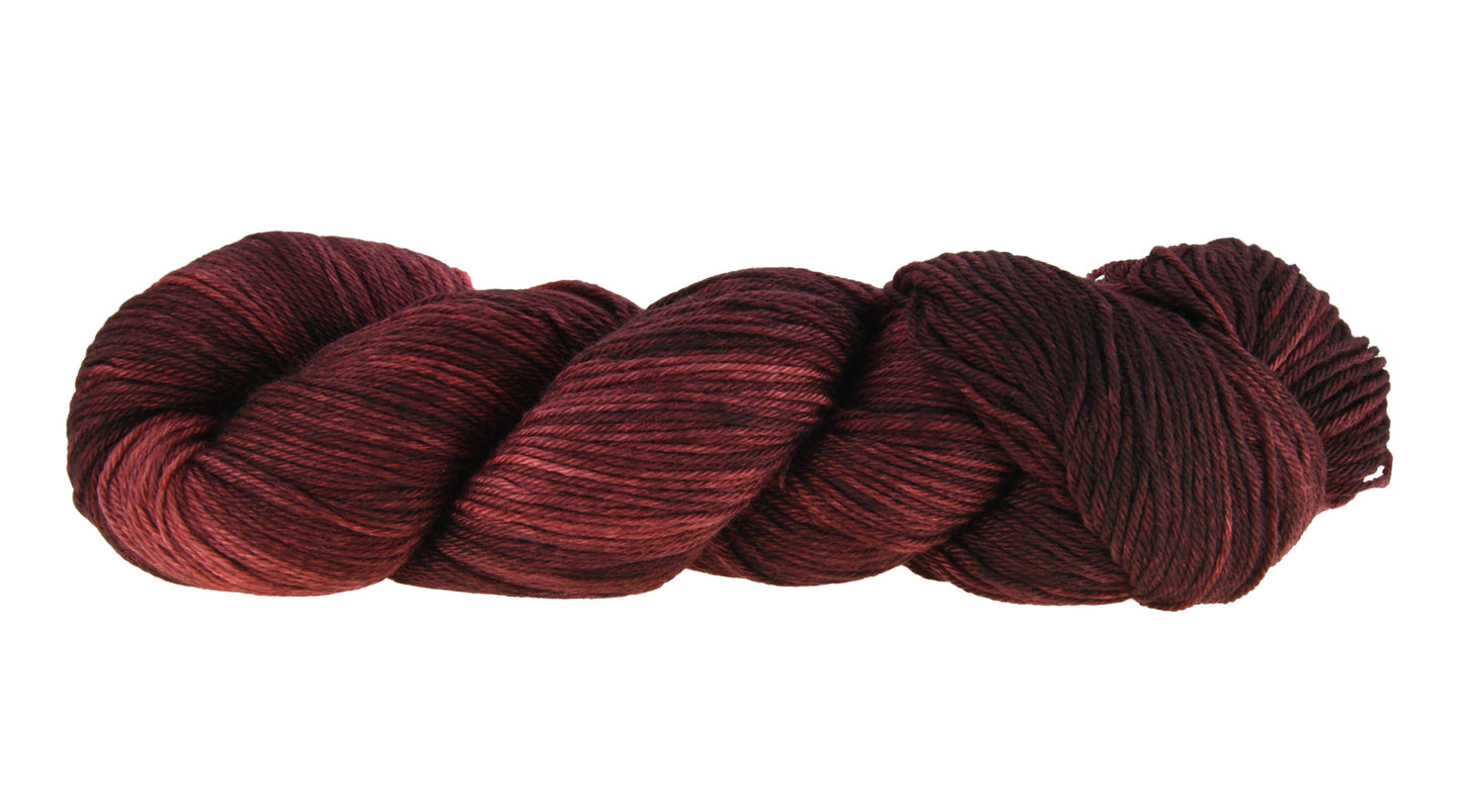 A twisted skein of Barn Yarn hand-dyed merino-cashmere-nylon yarn in colorway Chocolate Moose; a rich, earthy brown shade, perfect for warm and cozy knitting and crochet projects.