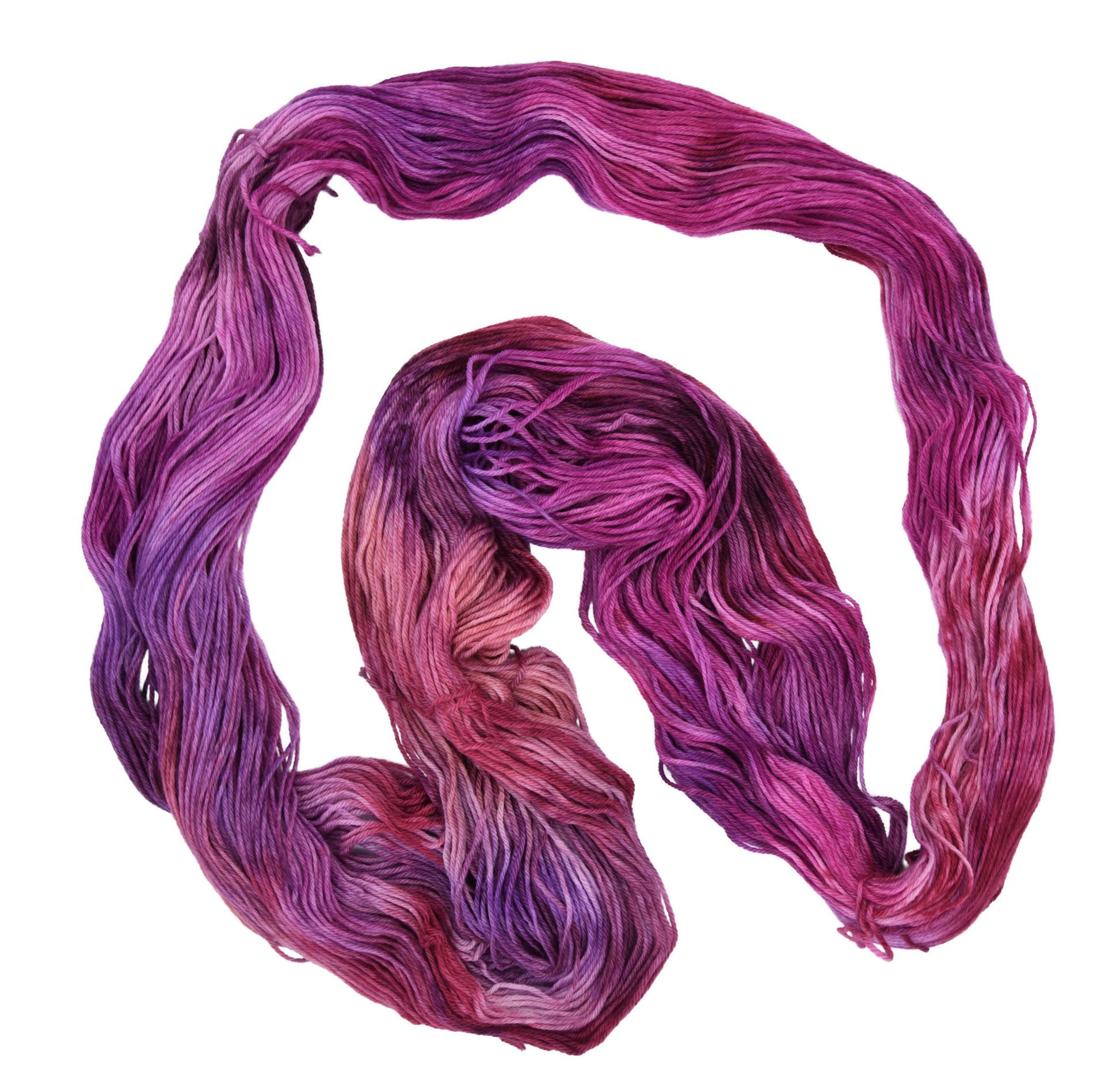 An unfolded skein of Barn Yarn hand-dyed merino-cashmere-nylon yarn in colorway Feelin’ Berry Glam! featuring vibrant berry tones with purple, pink, and jewel-like shades, perfect for stylish knitting and crochet projects.
