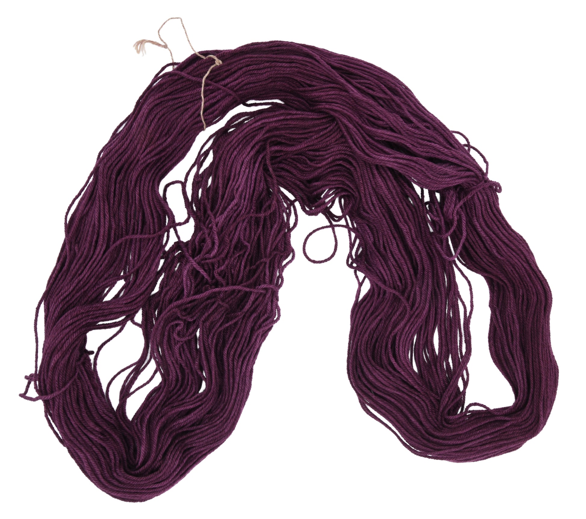 An unfolded skein of Barn Yarn hand-dyed worsted weight yarn in colorway Plum; a rich, deep purple shade, perfect for sophisticated knitting and crochet projects.