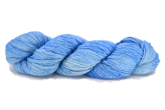 A twisted skein of Barn Yarn hand-dyed sport weight 100% alpaca yarn in colorway Jack Frost 100% - icy blue and frosty white tones, perfect for soft and elegant knitting or crochet projects.